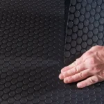 Black coin pattern garage flooring featuring raised, textured circles