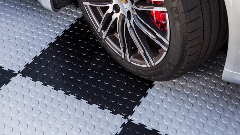 black and gray checkered garage floor tiles with a raised coin texture.
