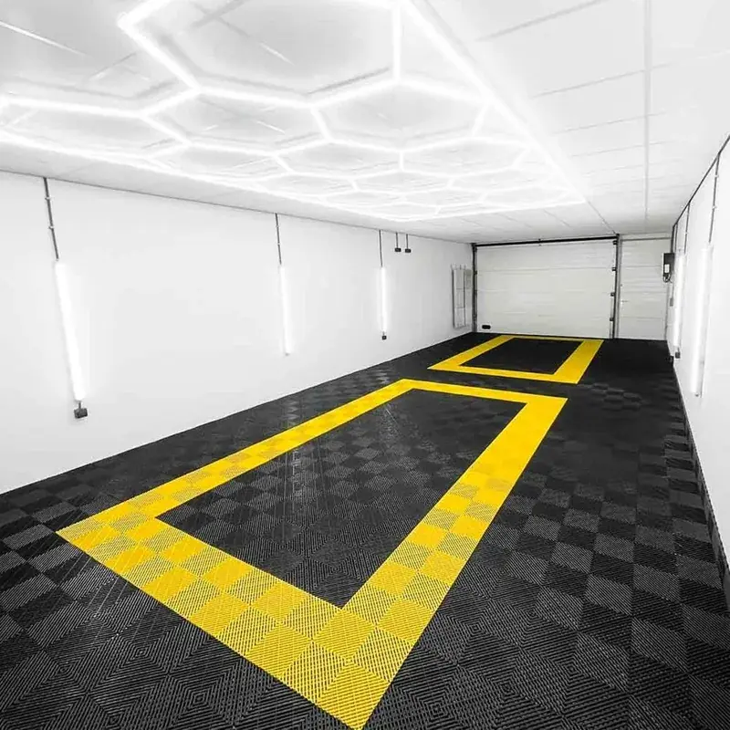 Empty garage with yellow-bordered tiles and hexagon lights