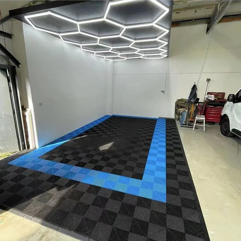 Garage with hexagon ceiling lights and blue-bordered floor.