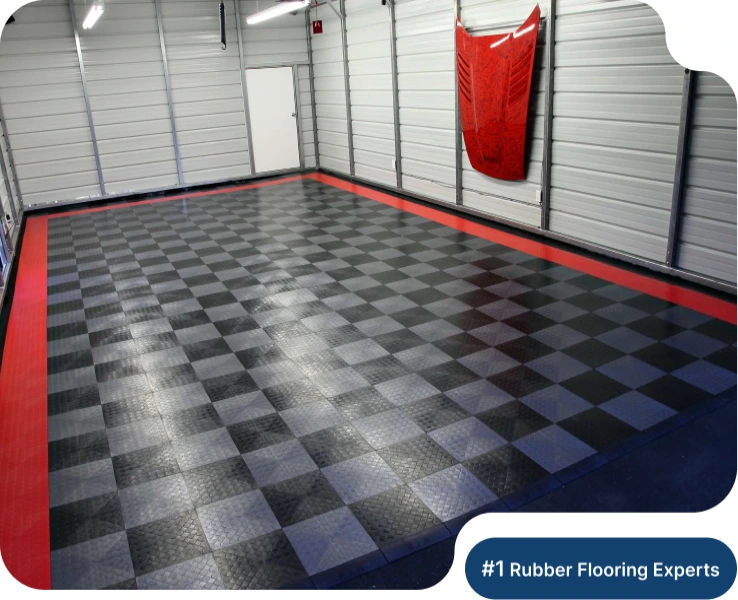 Interlocking rubber garage flooring tiles in a checkered diamond-plate design, featuring a custom red edge trim in a professional garage.