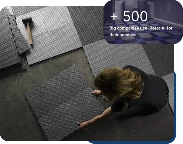 Installing gray interlocking floor tiles with rubber mallet